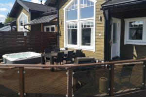 a deck with a tub and chairs on a house at Villa Peso1 - 9 henkilölle, HimosYkkösen alue in Jämsä