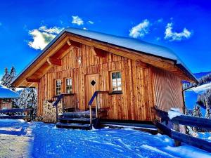 una cabaña de madera en la nieve con nieve en Jagdhütte mit Kaminofen und Sauna en Lachtal