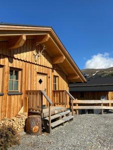 Cabaña de madera con porche y escaleras en la parte delantera en Jagdhütte mit Kaminofen und Sauna en Lachtal