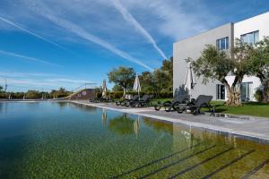 a swimming pool with chairs next to a building at Vila Gale Evora in Évora