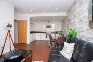 a living room with a couch and a kitchen at Fantastic City Centre Flat in Glasgow