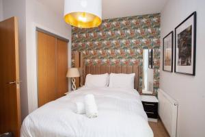 a bedroom with a large white bed with towels on it at Fantastic City Centre Flat in Glasgow