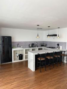 a kitchen with a bar with stools in it at Modern Apartment close to the airport ,Malls and beach in Lima