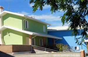 een groen huis met een blauw gebouw bij Ferienhaus für 5 Personen ca 60 qm in Rosolina Mare, Adriaküste Italien Venedig und Umgebung in Rosolina