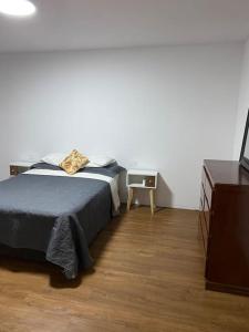 um quarto com uma cama, uma cómoda e uma televisão em Modern Apartment close to the airport ,Malls and beach em Lima