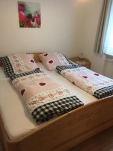 a bed with two pillows on top of it at Ferienwohnung in Frauenberg mit Garten in Haidmühle