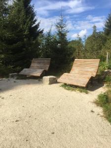 two wooden benches sitting on top of a dirt road at Ferienwohnung in Frauenberg mit Garten in Haidmühle