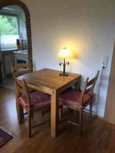 a wooden table with two chairs and a lamp on top at Ferienwohnung in Frauenberg mit Garten in Haidmühle