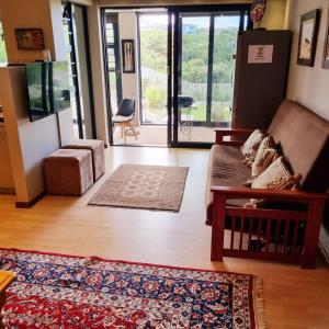 sala de estar con sofá y alfombra en Living on a Golf Estate, en Mossel Bay