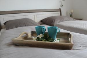 bandeja con dos tazas y flores en una cama en Ferienhaus Seaside, en Wunstorf