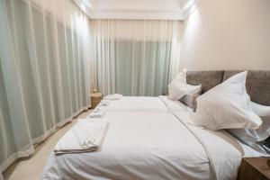 マラケシュにあるvotre oasis urbaine à l'hivernageのベッドルーム1室(白いシーツと枕のベッド2台付)