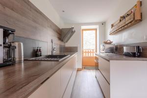 a kitchen with white cabinets and a counter top at Chalet Marijo: Sauna & Charme Alpin in Saint-Marcel