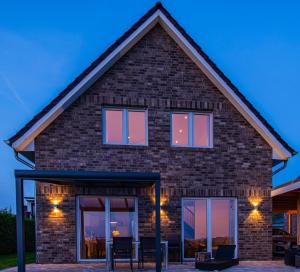 a brick house with windows at dusk at Haus Willi in Butjadingen