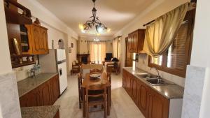a kitchen with wooden cabinets and a dining table at stratigato in Chios