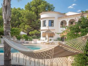 a hammock in front of a house with a pool at CostaBlancaDreams Casa Capritxu in Benissa in Fanadix