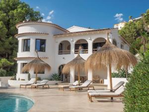 Villa con piscina y sombrillas de paja en CostaBlancaDreams Casa Capritxu in Benissa, en Fanadix