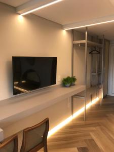 a living room with a flat screen tv on a wall at Mar de Bougainville in Governador Celso Ramos