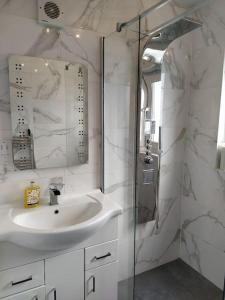 La salle de bains blanche est pourvue d'un lavabo et d'une douche. dans l'établissement Studio Flat, à Édimbourg