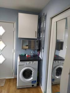 a laundry room with a washing machine and a washer at Studio Flat in Edinburgh