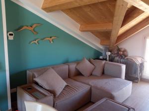 un soggiorno con divano marrone e soffitti in legno di Mansarda bijoux! 50mt dal mare con ampio terrazzino a Porto Recanati