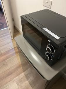 a microwave oven sitting on top of a table at Stylish and Spacious in Kettering