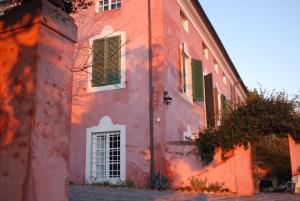 een rood gebouw met groene luiken erop bij Großes Ferienhaus in Bargecchia mit Privatem Pool in Corsanico-Bargecchia