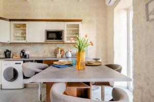 uma cozinha com mesa de jantar e cadeiras em Gallo House em Cospicua