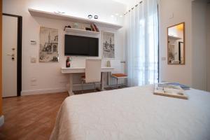Dormitorio con cama, escritorio y TV en Studio Apartment with Terrace - Parking, en Florencia
