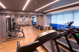 un gimnasio con cintas de correr y equipo cardiovascular en una habitación en St George Lycabettus Lifestyle Hotel, en Atenas