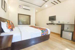 a bedroom with a bed and a tv in it at La Volga by Turtle Retreat in Morjim