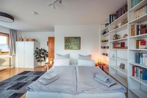 a bedroom with a large bed with bookshelves at Exklusives Josenhaus mit See- und Alpenblick & Gartensauna in Nonnenhorn