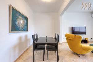 圣朱利安斯Stylish & Cosy 2BR Apt in the Heart of St' Julians by 360 Estates的一间带桌子和黄色椅子的用餐室