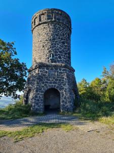 ein alter Steinturm auf einem Hügel mit Tür in der Unterkunft Ferienhaus Schwalbennest Schalkenmehren in Schalkenmehren