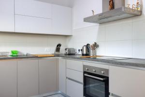 圣朱利安斯Stylish & Cosy 2BR Apt in the Heart of St' Julians by 360 Estates的厨房配有白色橱柜和炉灶烤箱
