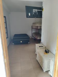 a room with a room with a bed and boxes at Casa de hóspedes Caraguatatuba in Caraguatatuba