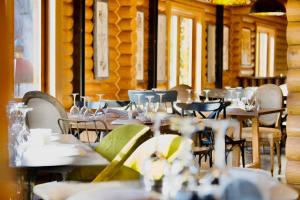 a restaurant with tables and chairs with glasses on them at Wood Hills Hotel & Resort in Mayrūbā