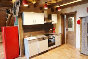 a kitchen with white cabinets and a red refrigerator at Fewo Schwarzwaldblick, 3 Schlafzimmer Todtnau-Muggenbrunn, Liftverbund Feldberg in Muggenbrunn