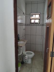 a small bathroom with a toilet and a sink at Casa de hóspedes Caraguatatuba in Caraguatatuba