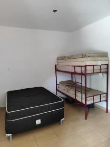 two bunk beds in a room next to a wall at Casa de hóspedes Caraguatatuba in Caraguatatuba