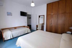 a hotel room with two beds and a tv at Hotel Marinella in Marciana Marina