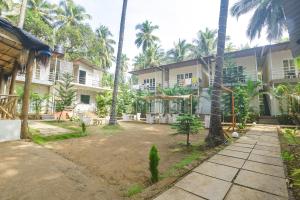 an exterior view of a resort with palm trees at La Volga by Turtle Retreat in Morjim