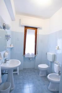 a bathroom with a sink and a toilet and a window at Hotel Marinella in Marciana Marina