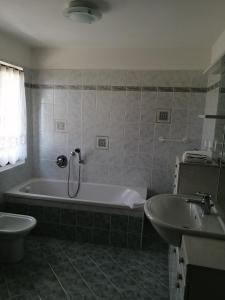 a bathroom with a tub and a toilet and a sink at Nadia Haus in Luserna