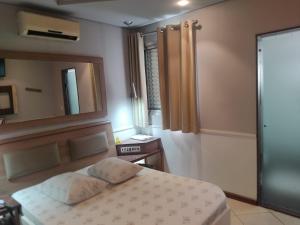 a bedroom with a bed and a mirror at Hotel Nova Lisboa - Adult Only- in Sao Paulo