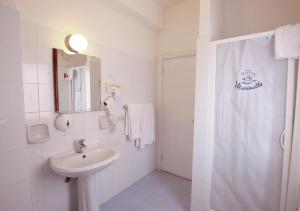 y baño blanco con lavabo y ducha. en Hotel Marinella, en Marciana Marina