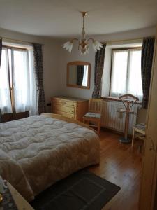 a bedroom with a bed and a dresser and windows at Nadia Haus in Luserna