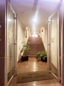 a hallway with stairs and potted plants in a building at Hotel Nova Lisboa - Adult Only- in Sao Paulo