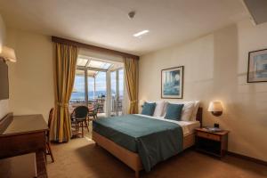 a hotel room with a bed and a balcony at Grand Hotel Bonavia in Rijeka