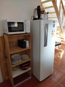 a kitchen with a microwave and a refrigerator at Cabañas Nelly in Frutillar