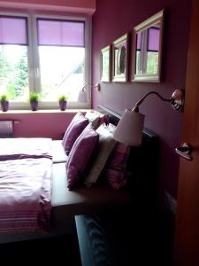 een slaapkamer met een bed, een lamp en ramen bij Ferienwohnung in der Kaschubei, in ruhiger Lage am Waldrand, in der Nähe von Danzig und Sopot in Sulmin